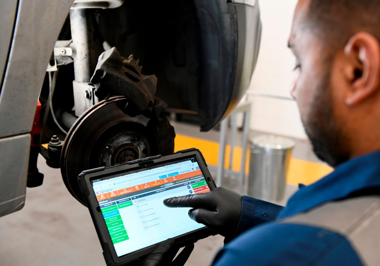 Man and woman talking on a sunny day at the rental car lot.