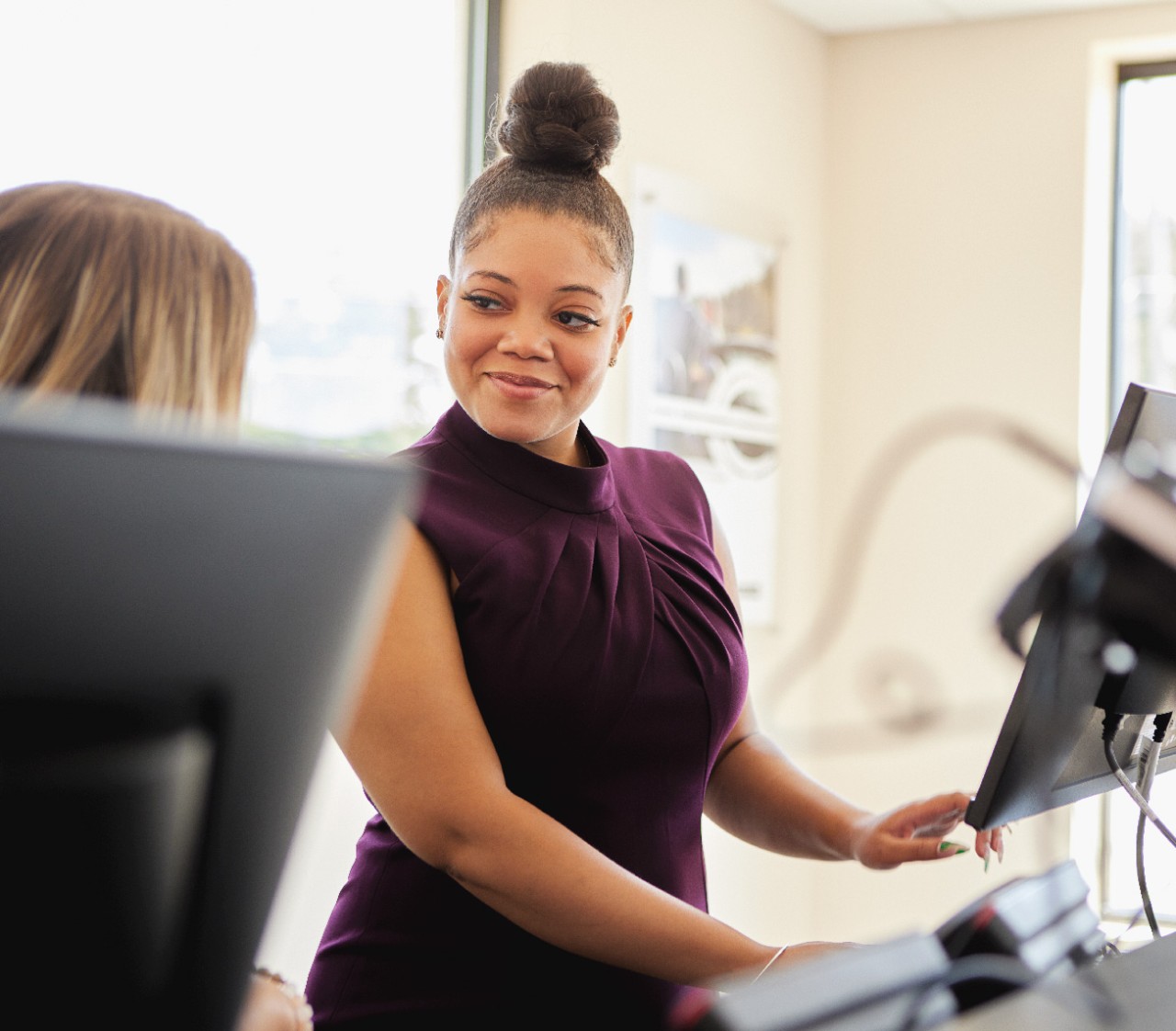 Man and woman talking on a sunny day at the rental car lot.