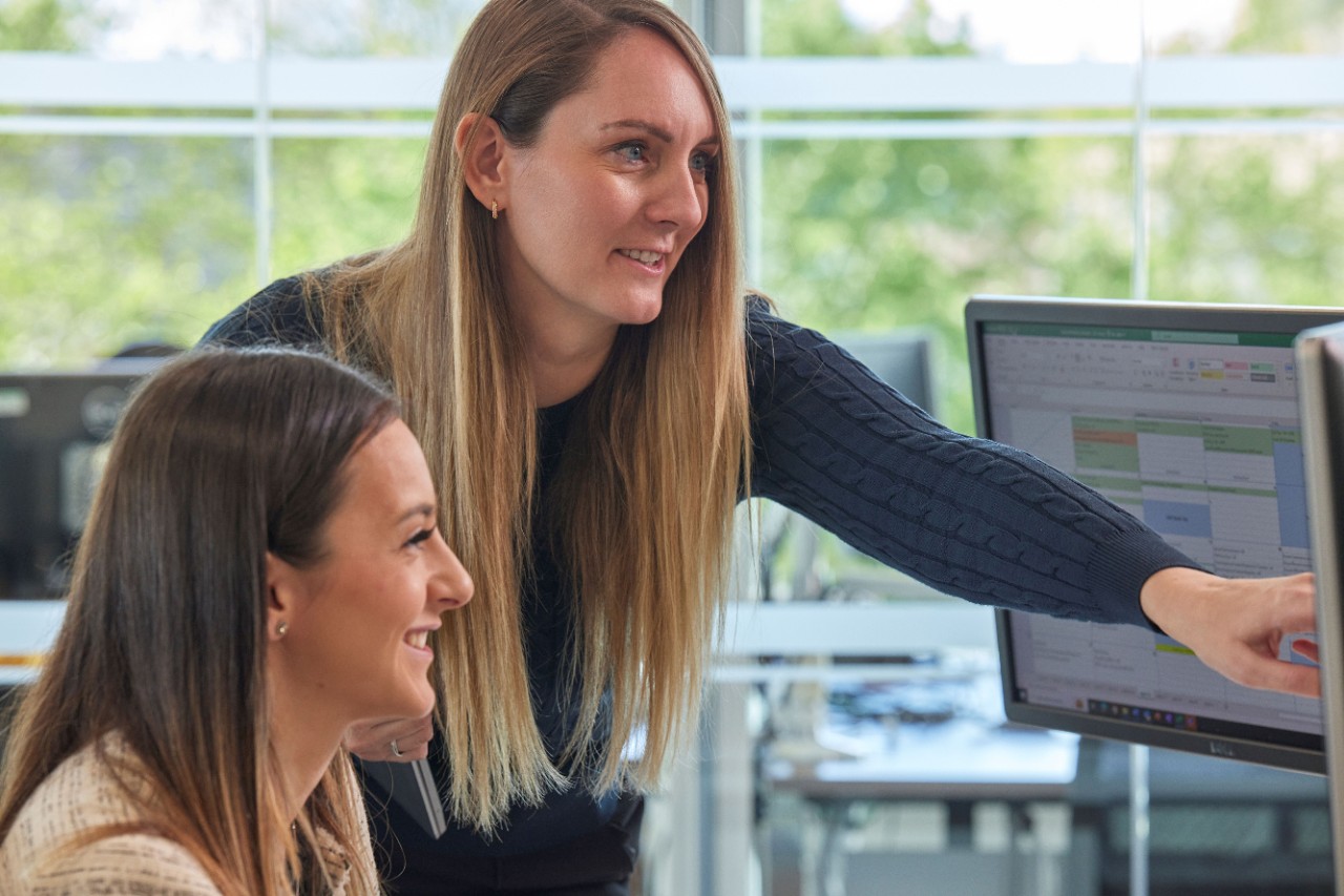Two team members looking at computer screen
