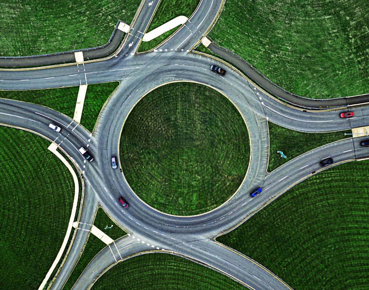 Aerial view of a highway interchange with cars moving on and off the ramps.