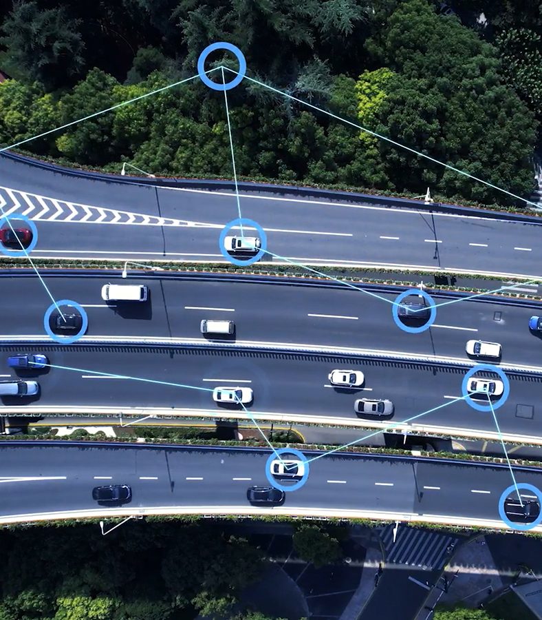 An aerial shot of several cars on the interstate with icons throughout