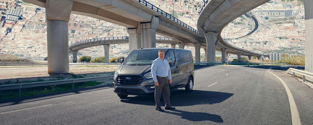 Man standing in front of a car on the interstate