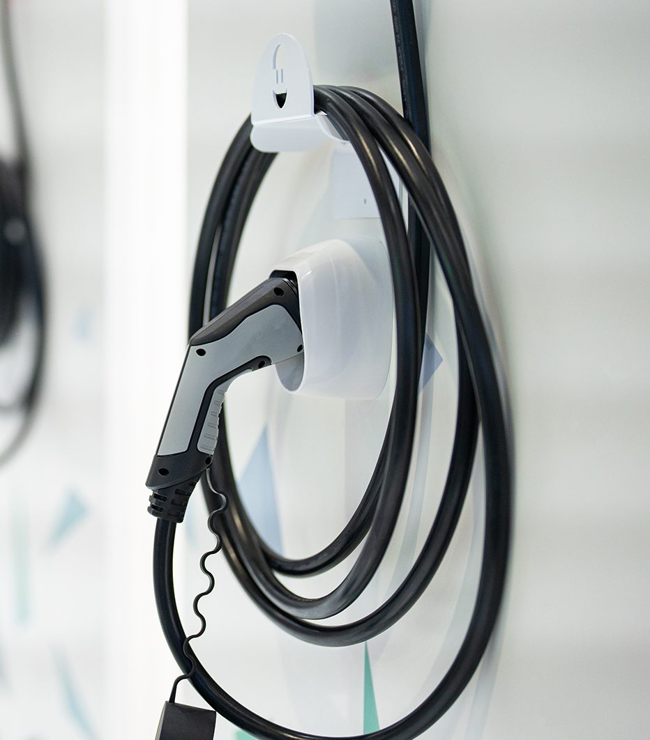 An electric vehicle charge hanging on a white wall