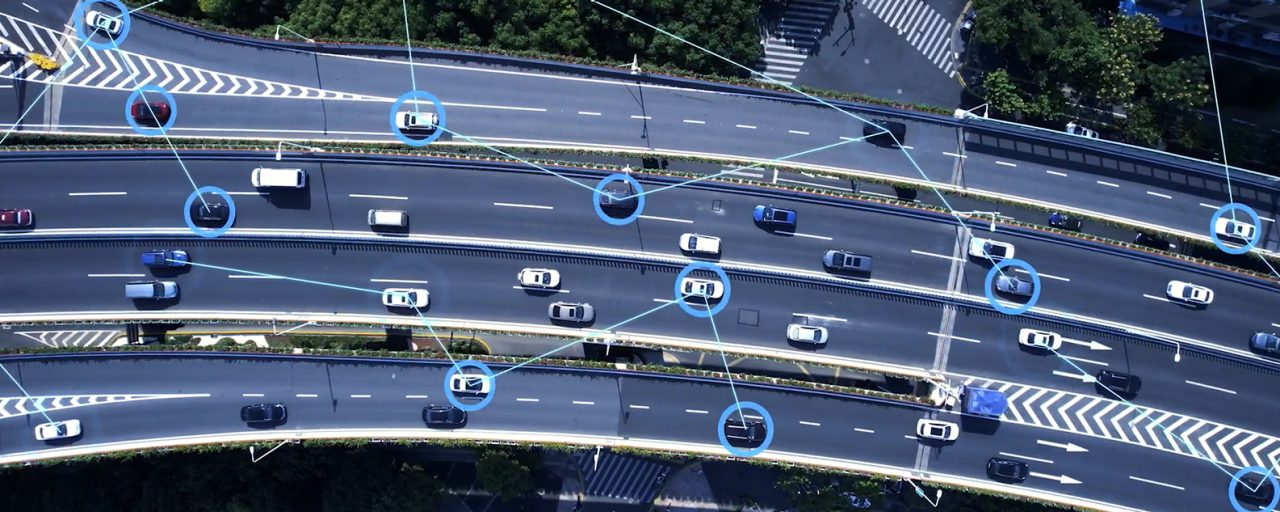 An aerial shot of several cars on the interstate with icons throughout