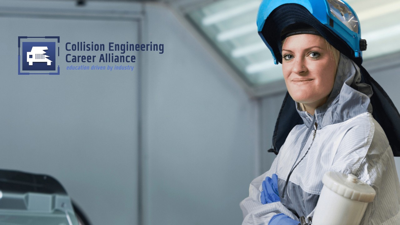 A female in the collision engineering program smiles while wearing her equipment